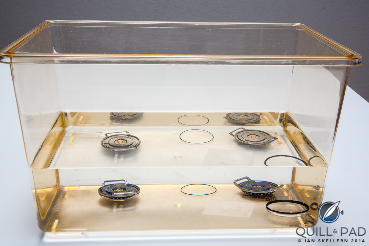 How many movements are in the fluid? Only two: the top is a reflection (not refraction) of the two below. The dial modules rest in fluid for days to ensure that there are trapped air bubbles. The sealing plate sandwiched between the top fluid-filled module (housing the dial) and dry bottom section (housing the movement) is attached under the fluid so avoid air entering