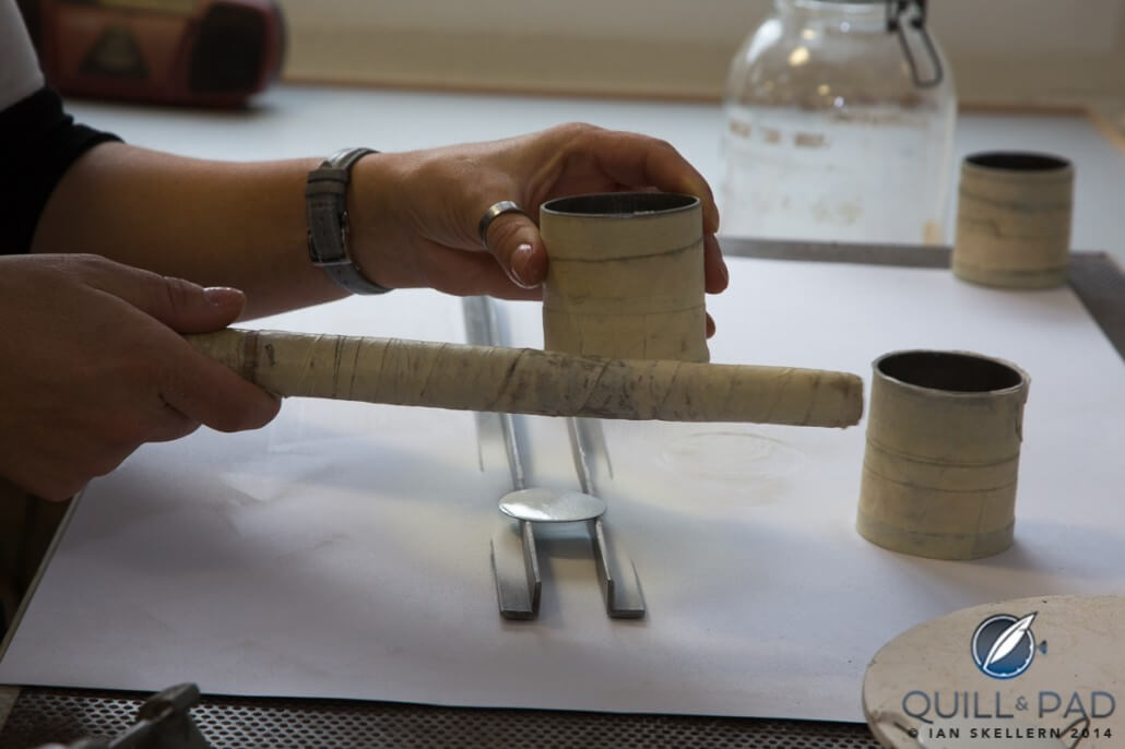 A fine layer of powdered enamel (basically crushed glass) is tapped from a sieve onto a dial