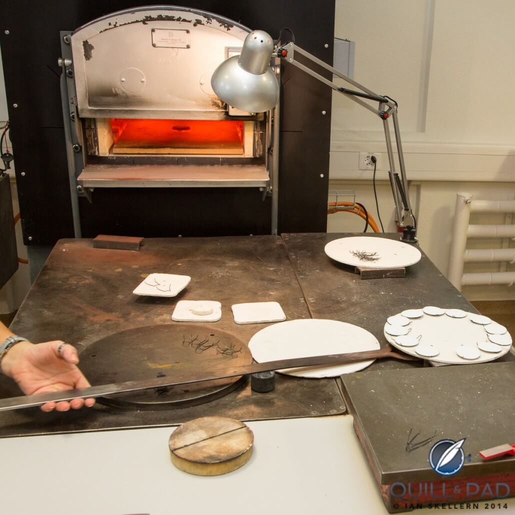 A plate of dials covered with enamel powered is ready for firing in the kiln