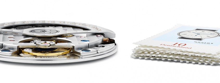 Nomos Glashütte’s automatic Caliber DUW 3001, only 3.2 mm in height, next to a small pile of stamps