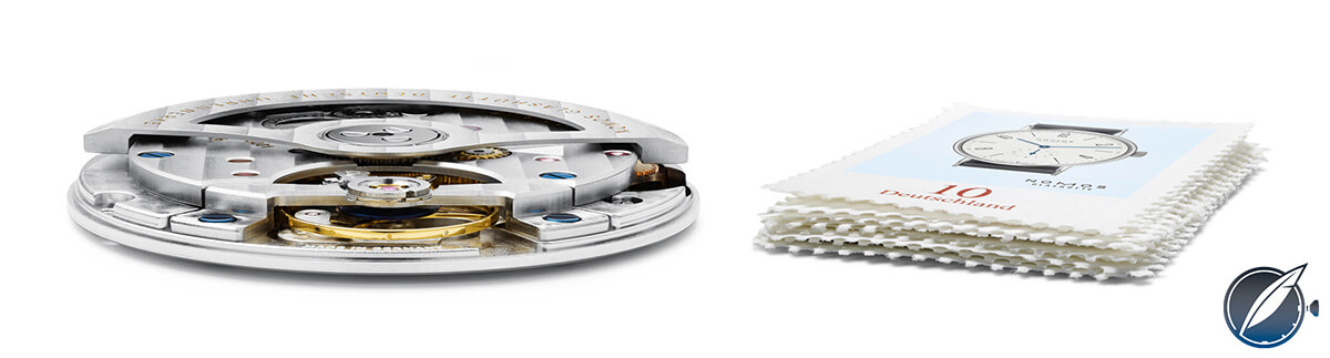 Nomos Glashütte’s automatic Caliber DUW 3001, only 3.2 mm in height, next to a small pile of stamps