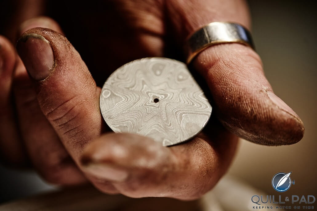 Johan Gustafsson holds a damascened steel dial patterned with his signature “wildflowers” that is ready for etching (photo courtesy Björn Dahlgren) 