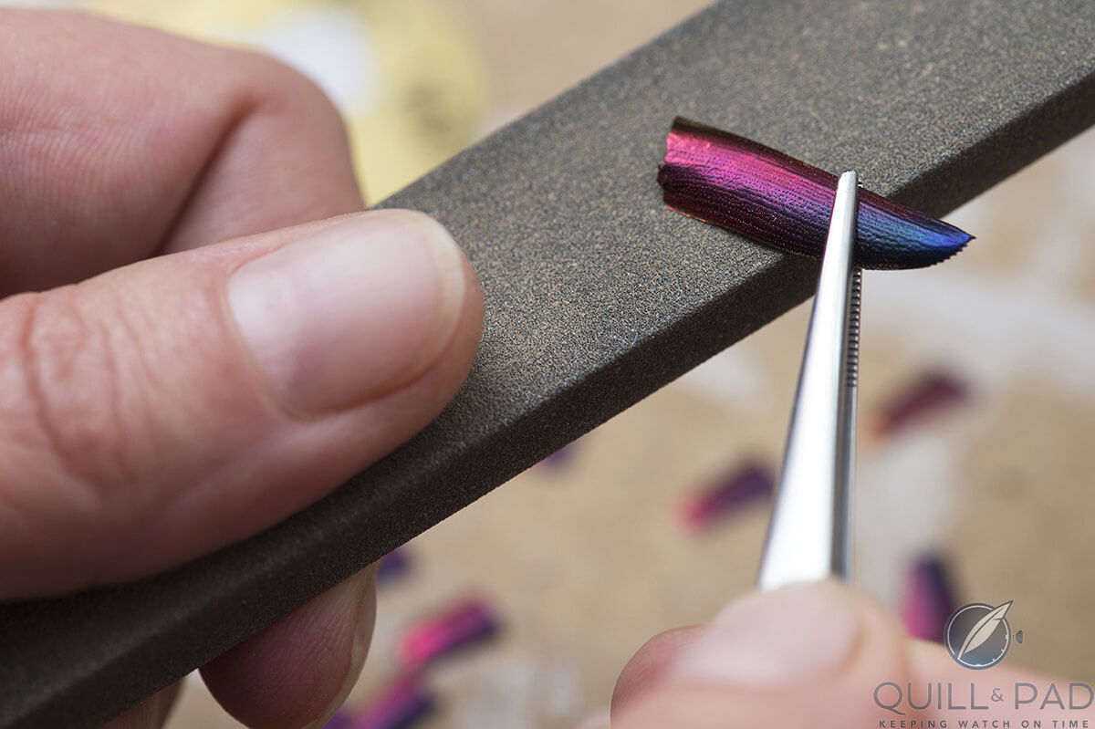 Carefully sanding a scarab shell into the desired shape before adding to mosaic dial of the Hermès Arceau Pocket Ailes et Ecailles