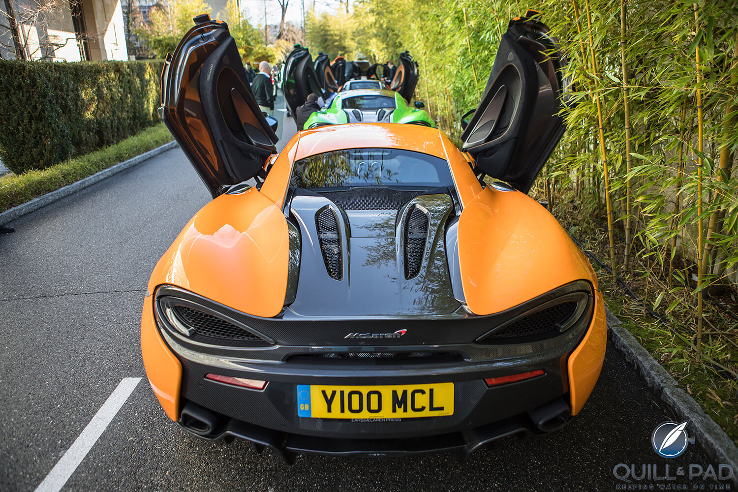 Doors wide open: view from the back of parked McLaren 570s supercars