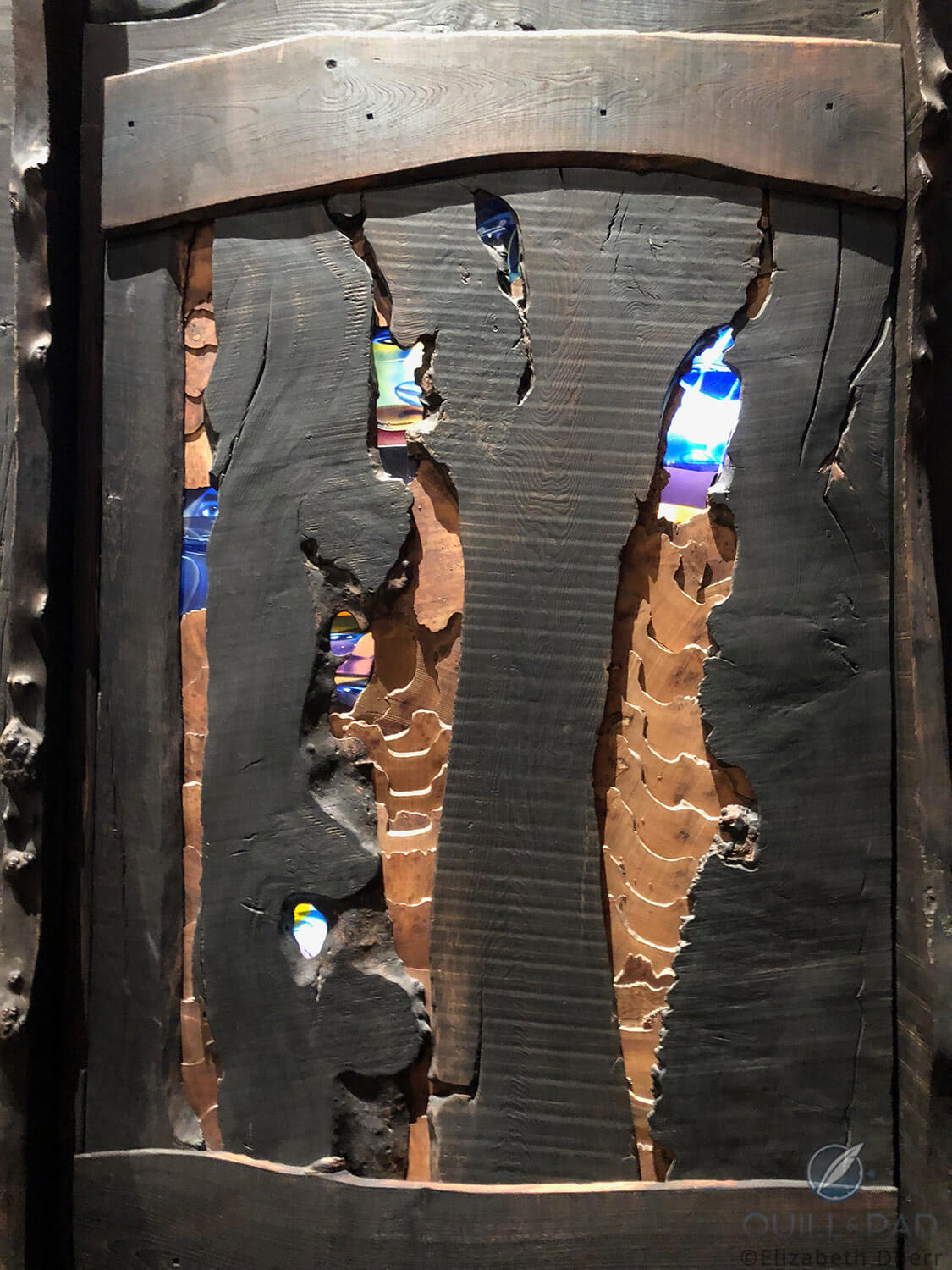 A side view of Edinburgh’s Millennium Clock Tower with burnt-out wood and stained glass paneling the crypt portion