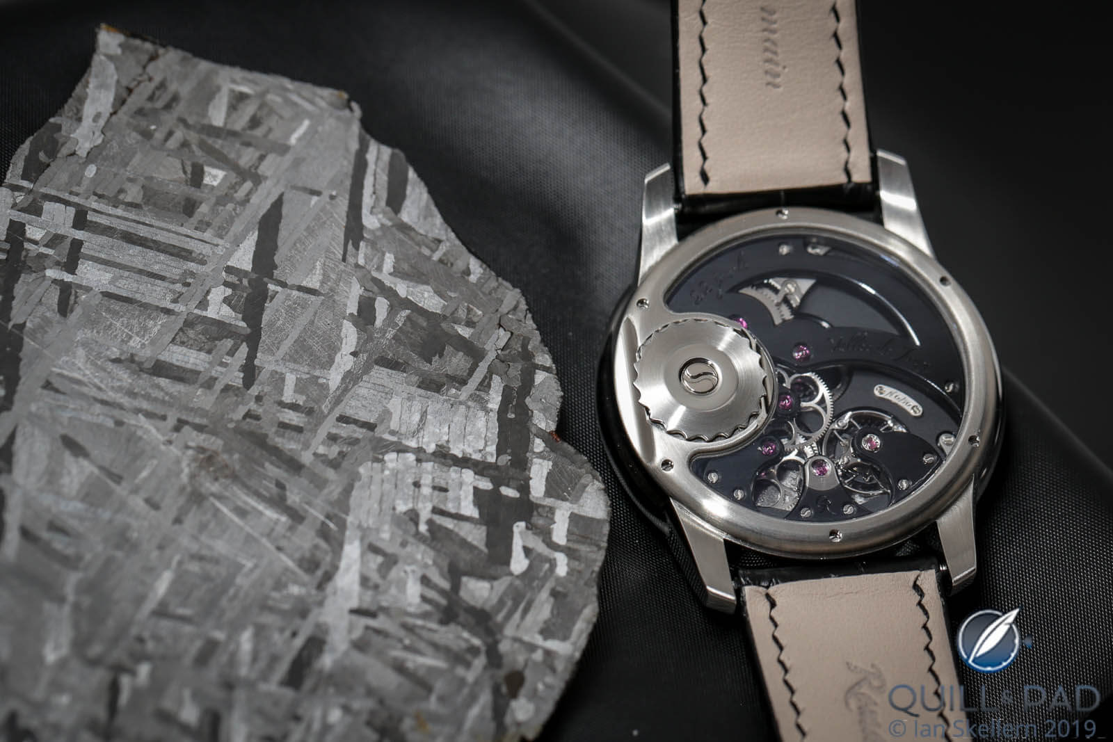 Back of the Romain Gauthier Prestige HMS Meteorite beside a piece of the Henbury metorite that the dial was crafted from